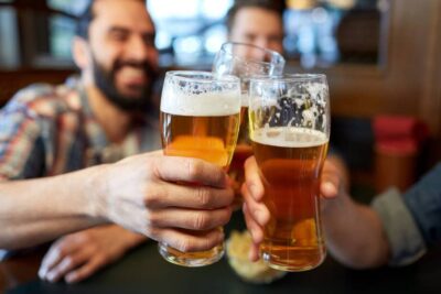 happy male friends drinking beer at bar or pub