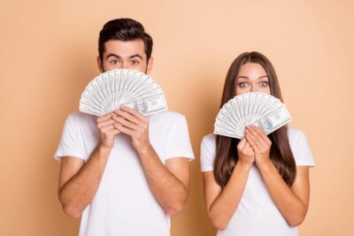 Couple-holding-stacks-of-money