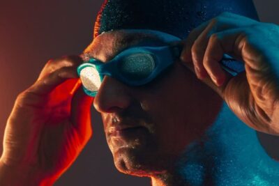 CloseUpWetManAdjustingGogglesUnderDramaticLighting