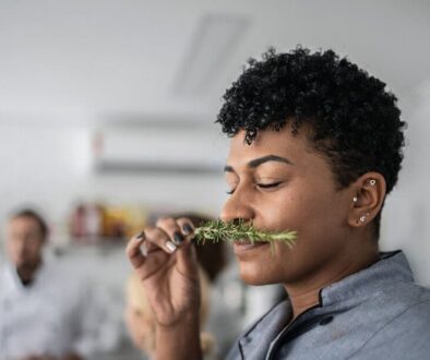 Woman smelling fresh herbs in a cooking class
