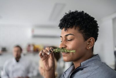 Woman smelling fresh herbs in a cooking class