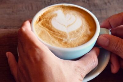 HandsPickingUpaWhiteCoffeeCup